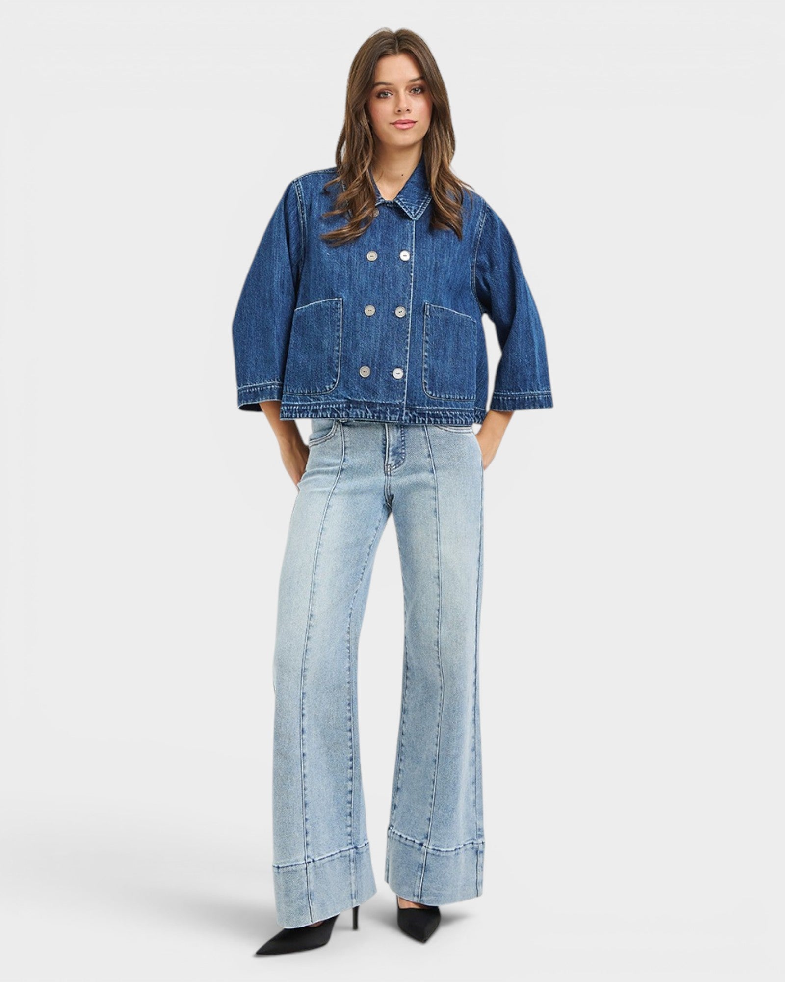 Woman wearing a denim jacket and jeans on a white background