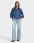 Woman wearing a denim jacket and jeans on a white background