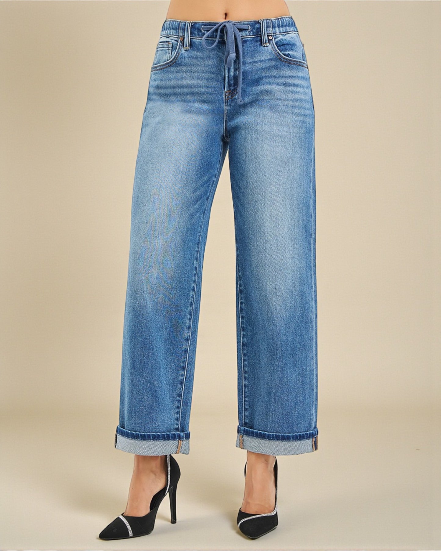Wide-leg jeans worn by a person on a beige background