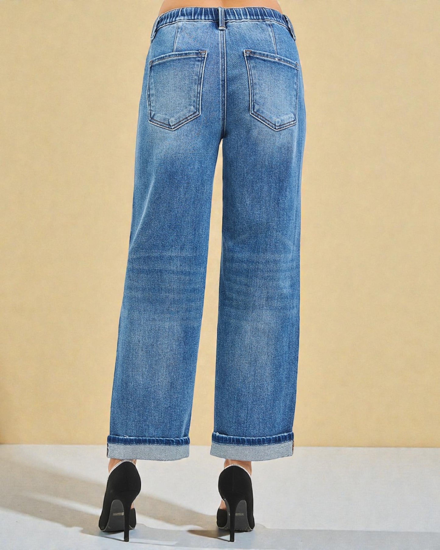 Blue jeans worn by a person on a beige background