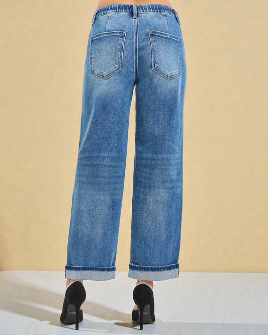 Blue jeans worn by a person on a beige background