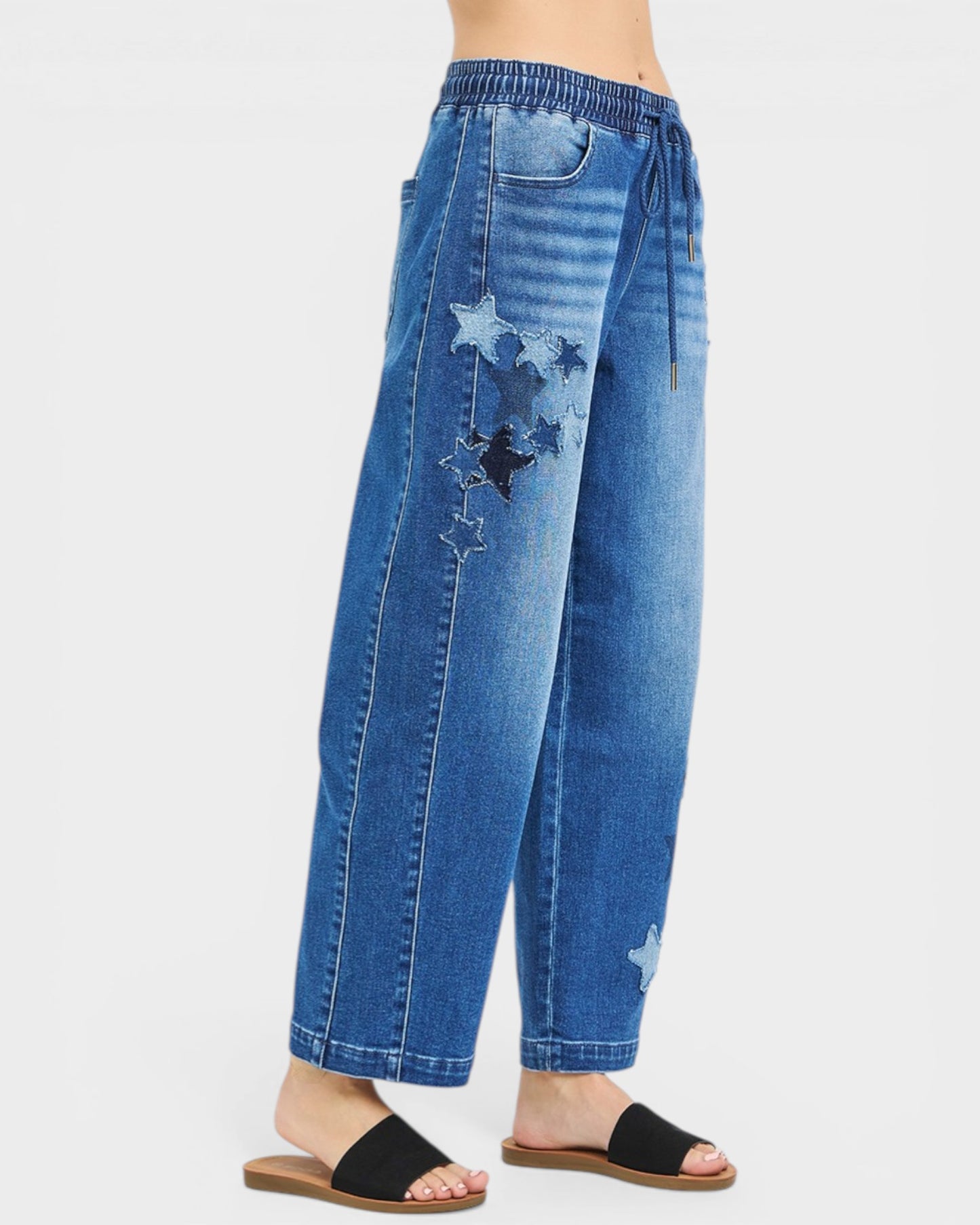 Blue jeans with star patches on a white background