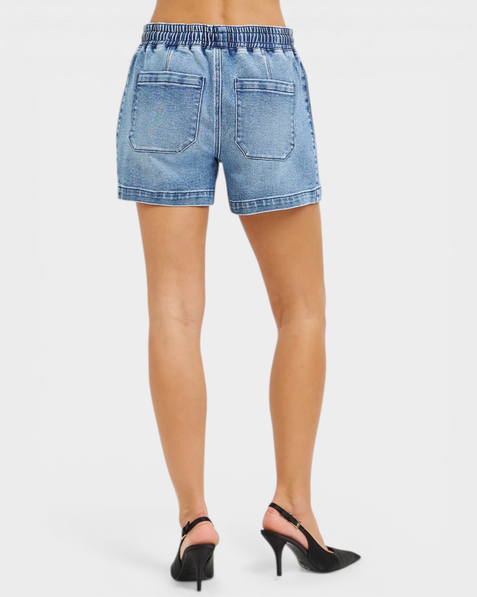 Denim shorts worn by a person on a white background