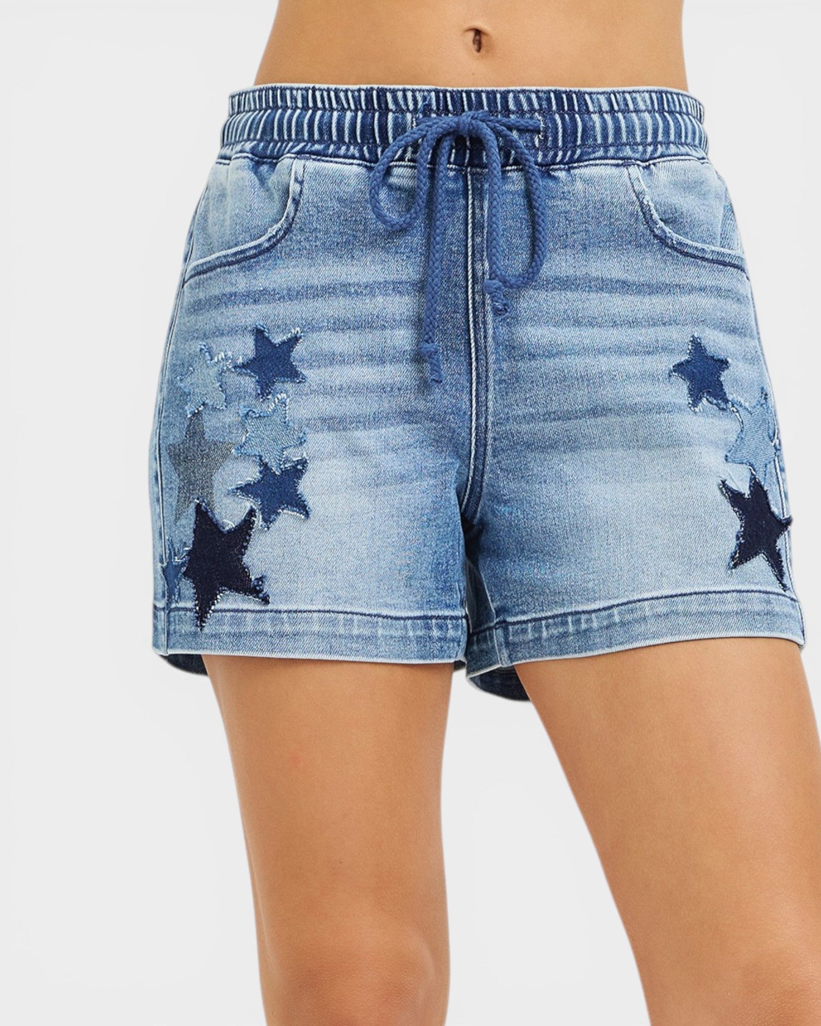 Denim shorts with star patterns on a white background