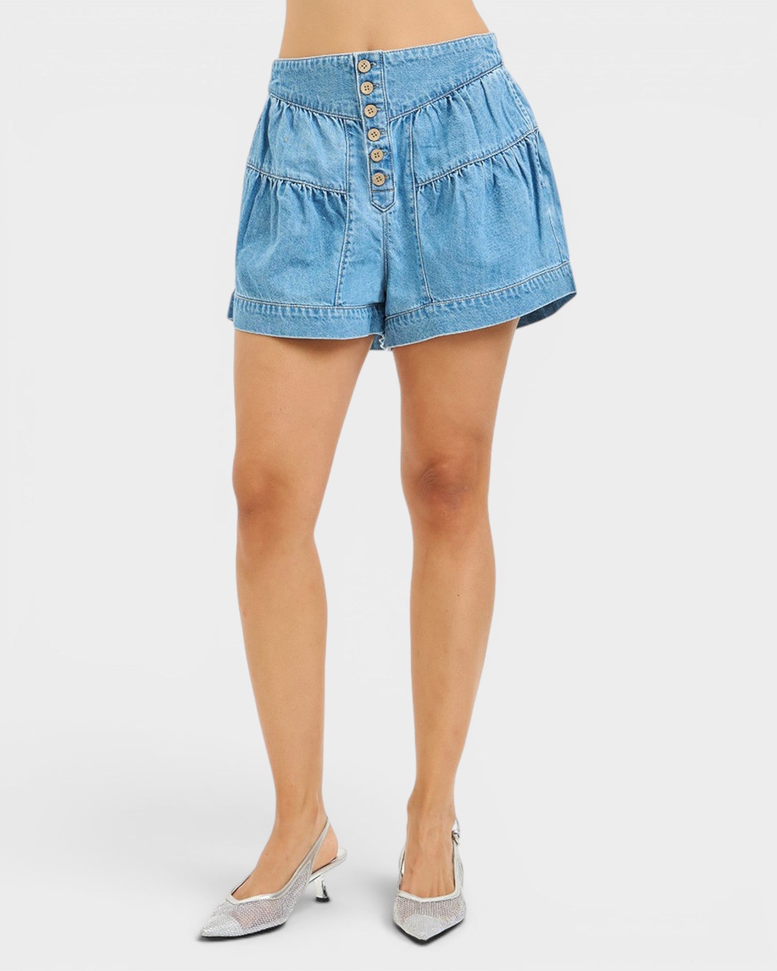 Blue denim shorts worn by a person on a white background
