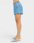 Light blue denim skirt worn by a person on a white background