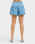 Blue denim shorts worn by a person on a white background