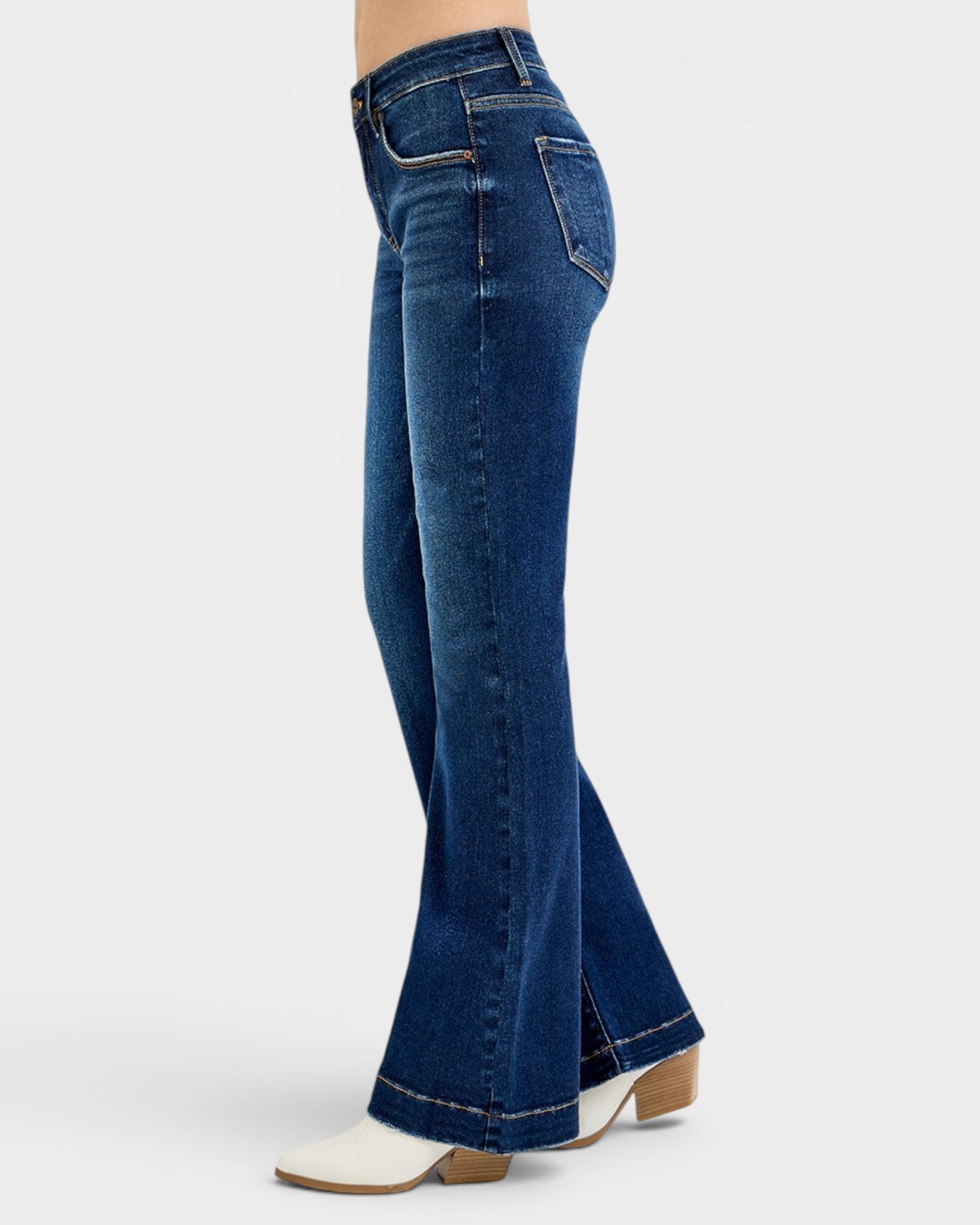 Blue flared jeans worn by a person on a white background