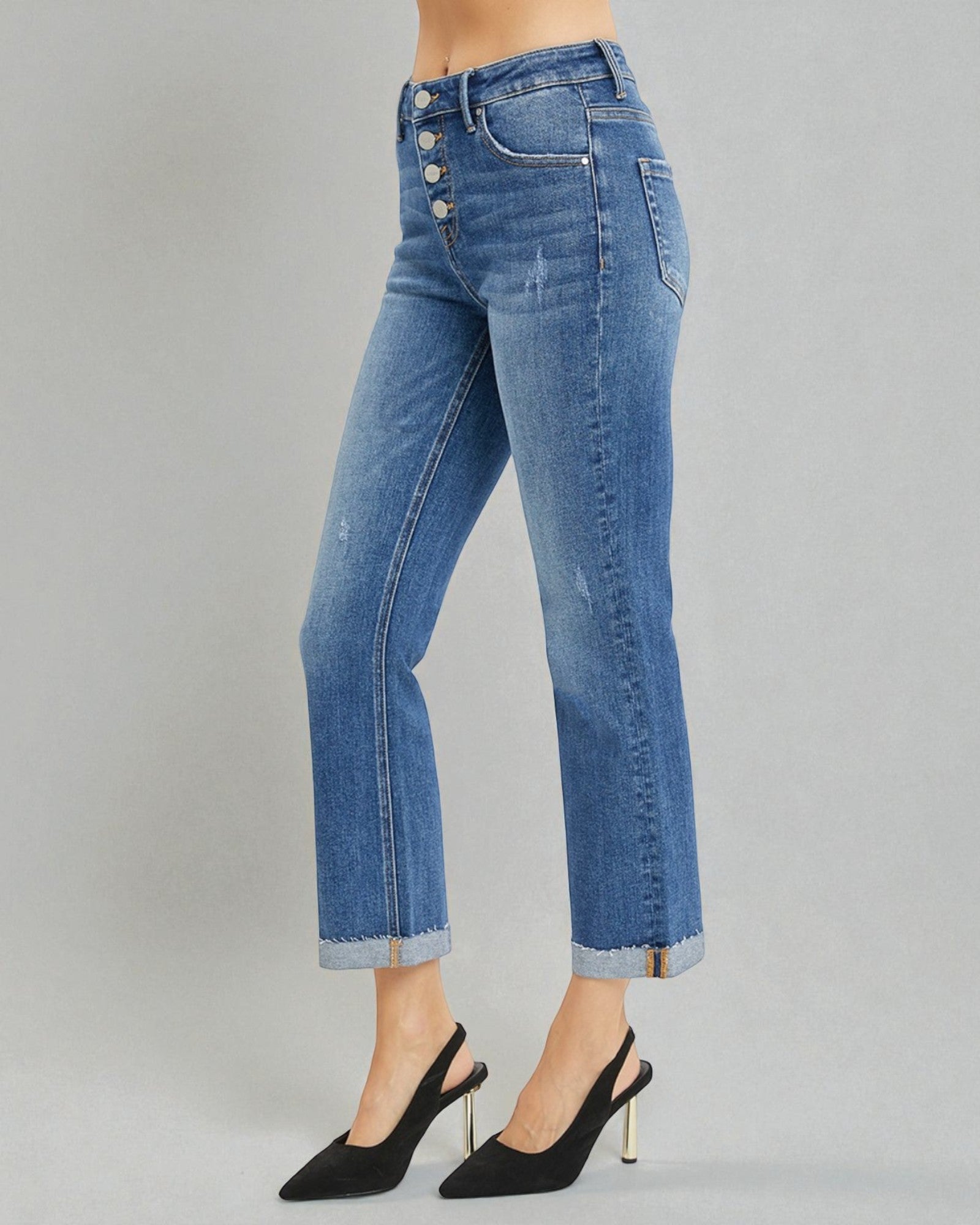 Blue jeans worn by a person on a gray background