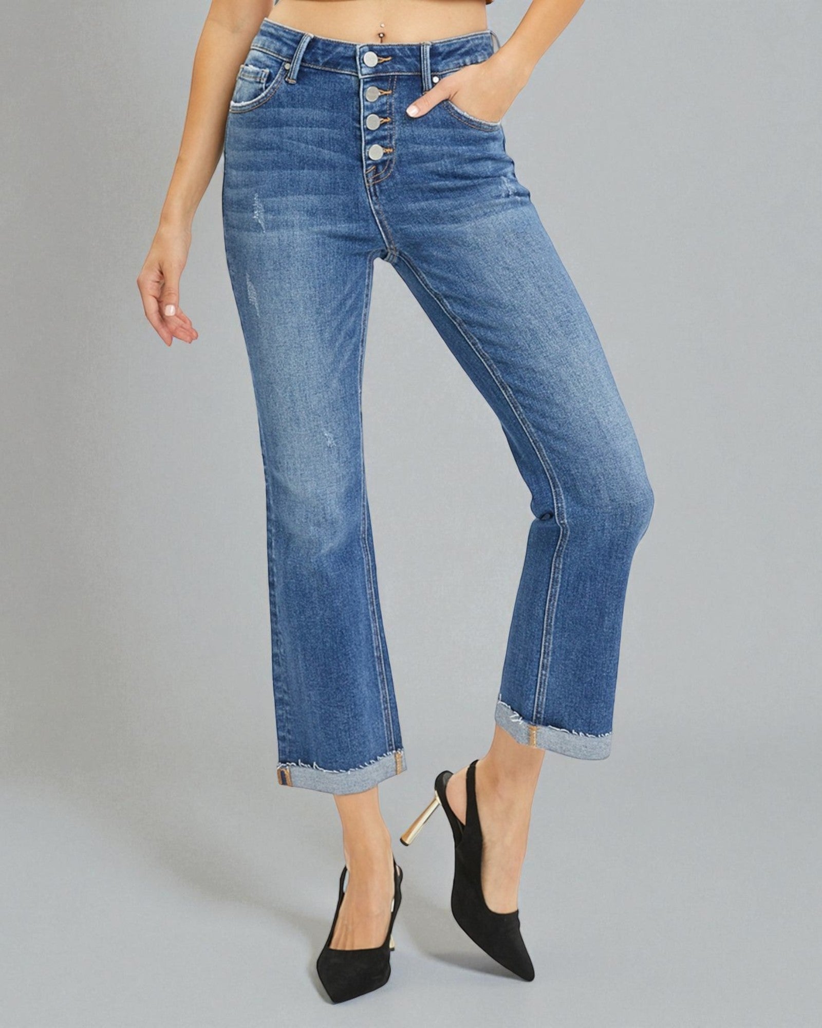 Person wearing blue jeans with a gray background