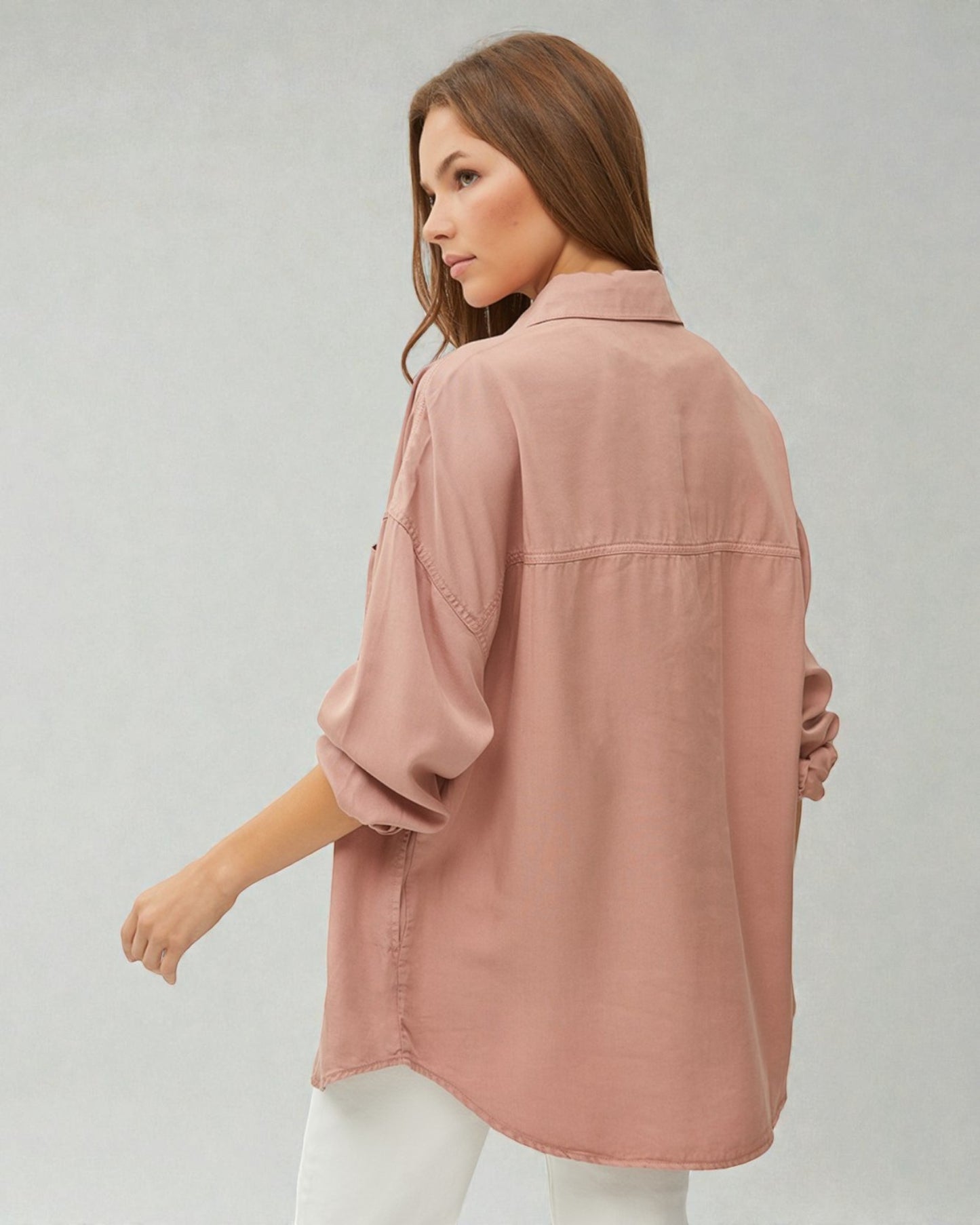 Woman wearing a pink shirt against a gray background