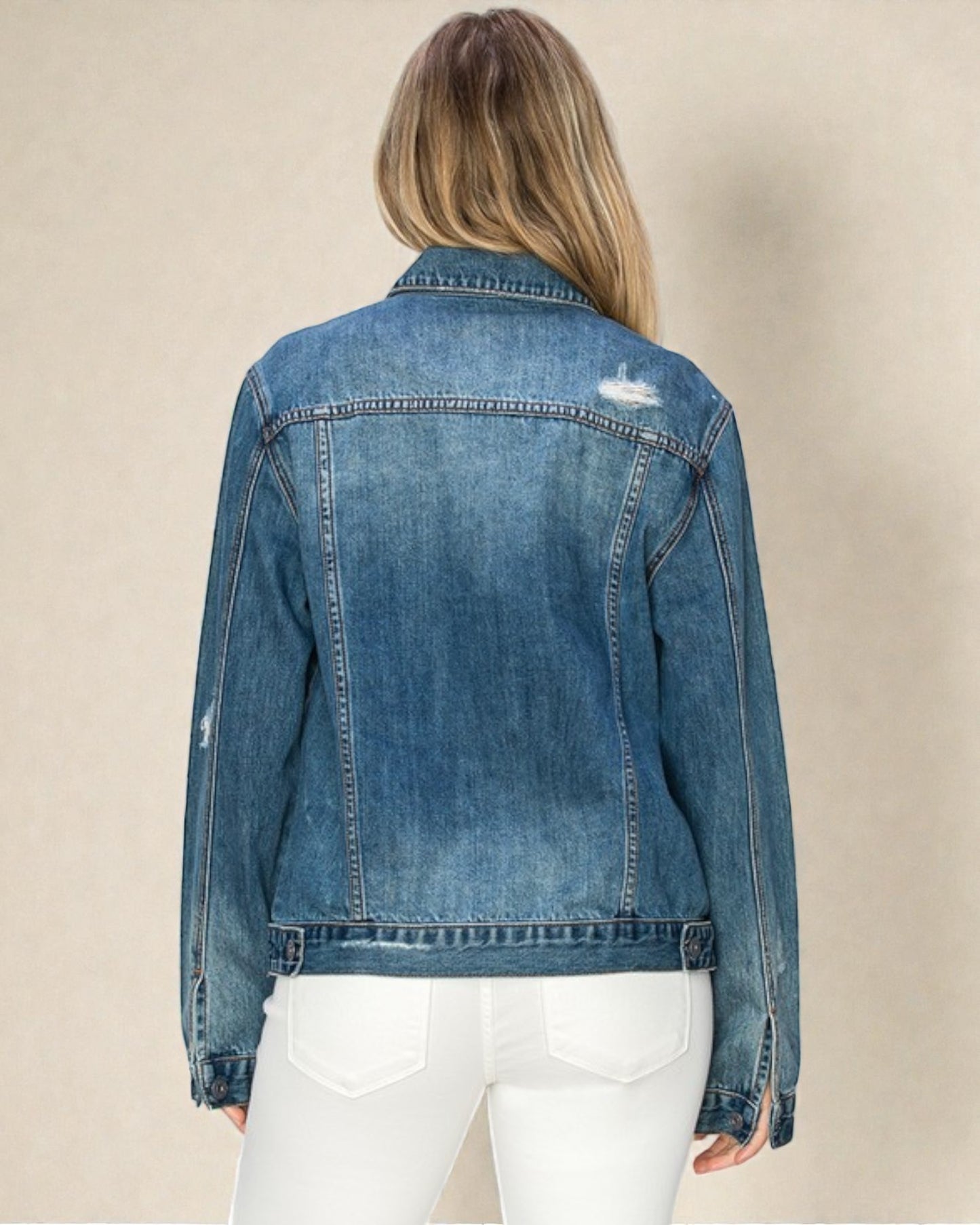 Denim jacket worn by a person on a beige background