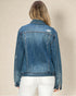 Denim jacket worn by a person on a beige background