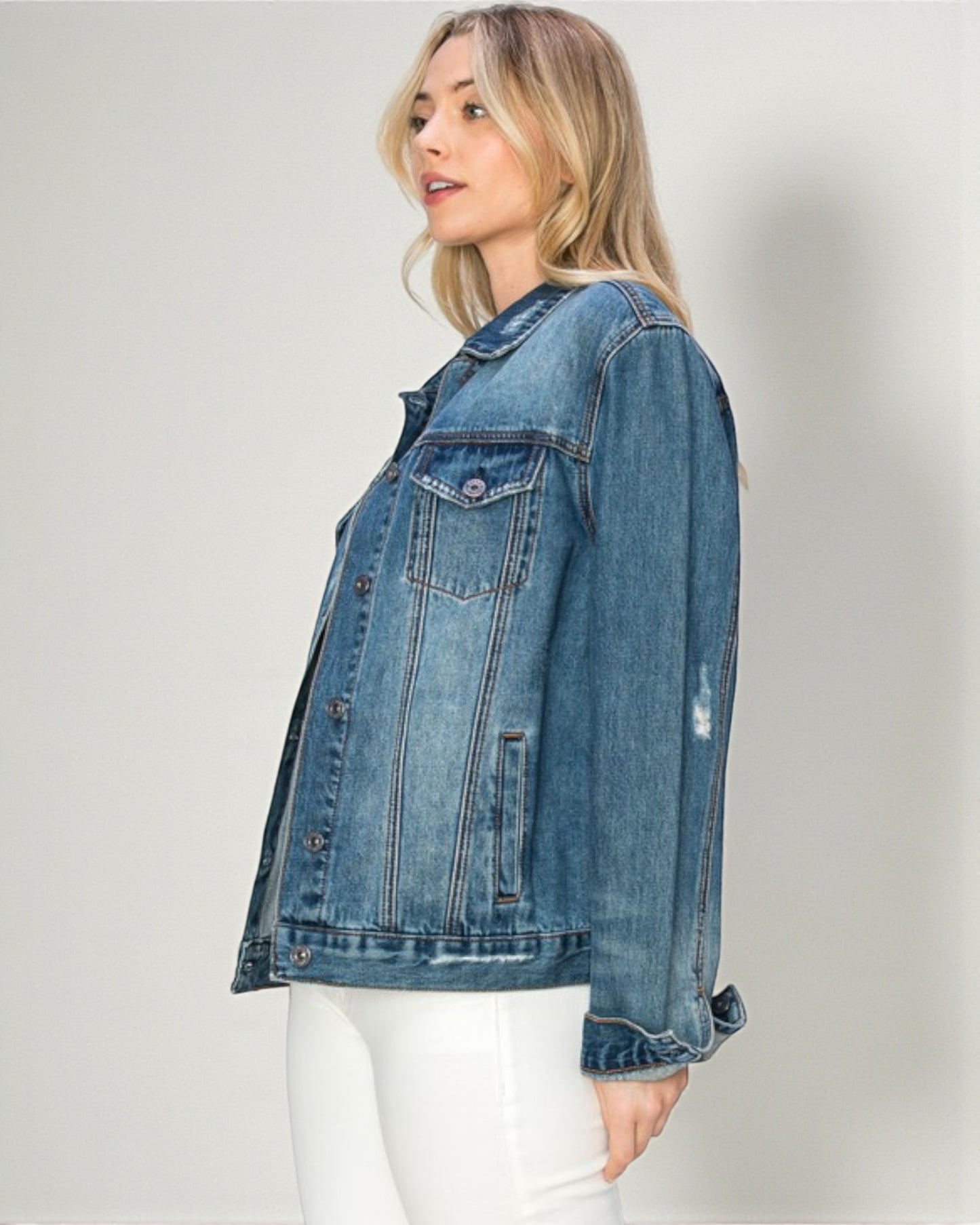 Woman wearing a blue denim jacket on a plain background