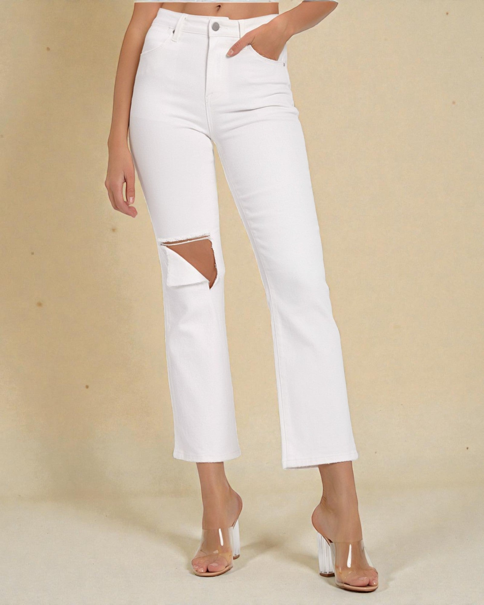 White jeans with cut-out design on a beige background