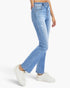 A person wearing light blue high-rise distressed jeans with a slight flare, paired with white sneakers, shown from the waist down against a plain white background.