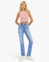 A blonde model wearing a red and white striped sleeveless crop top, light wash blue high-waisted jeans with distressed details, and white sneakers, standing against a light gray studio background.