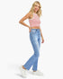 A woman modeling a red and white striped crop top, light blue high-waisted flare jeans, and white sneakers against a plain white background.