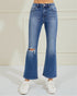 Blue jeans with a distressed knee on a white background
