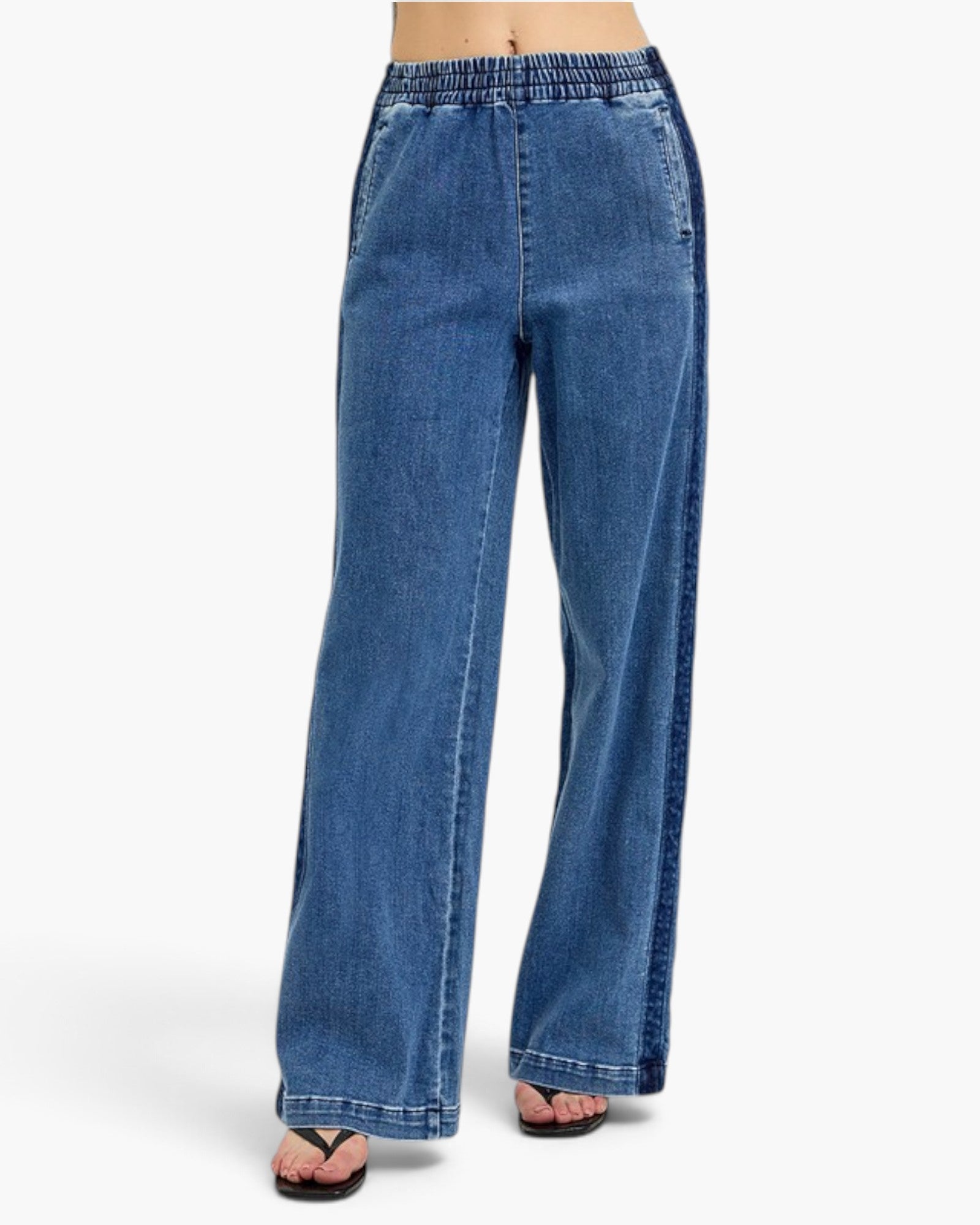 A person wearing blue wide-leg denim jeans with an elastic waistband, shown from the waist down against a plain light background.