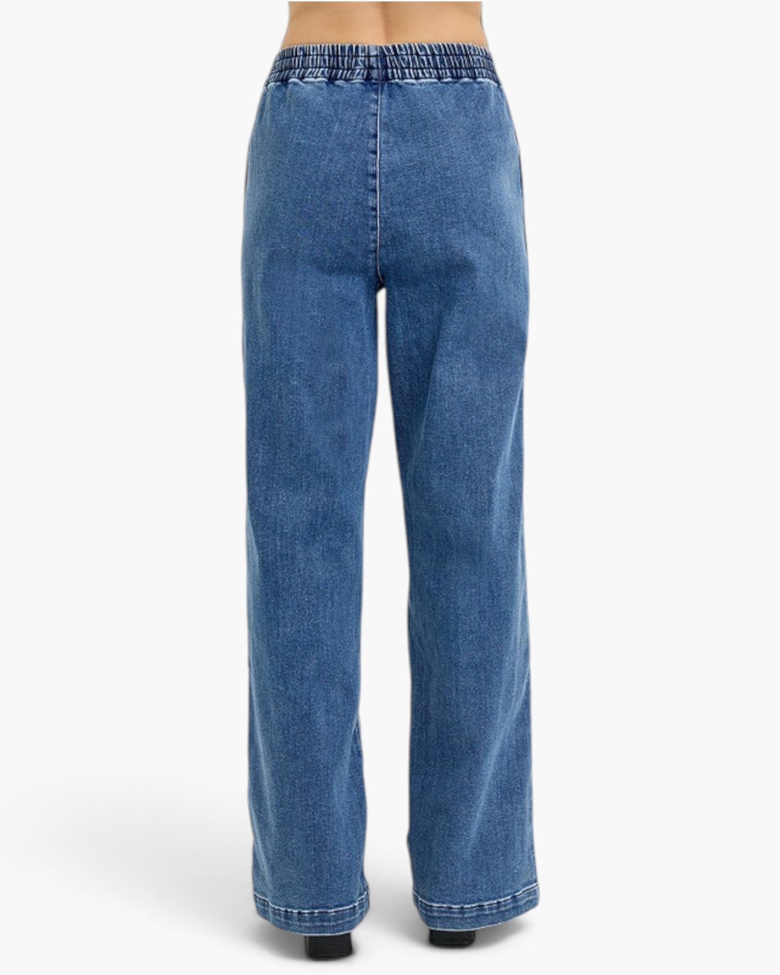 A pair of wide-leg blue denim jeans with an elastic waistband, shown from the back on a model against a plain white studio background.