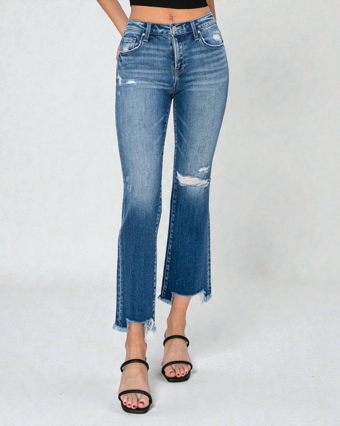 Blue jeans with distressed details on a white background