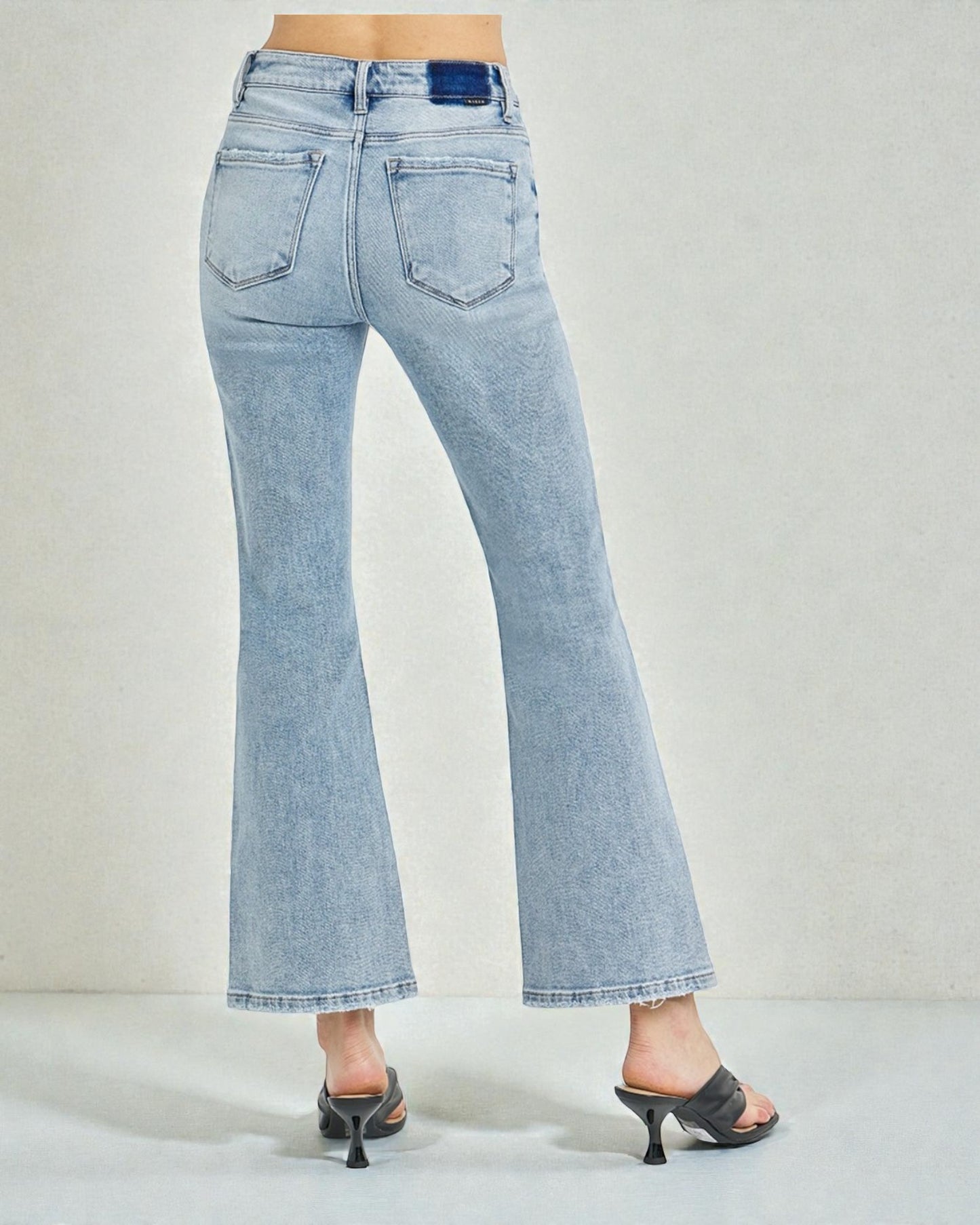 Light blue jeans worn by a person on a plain background