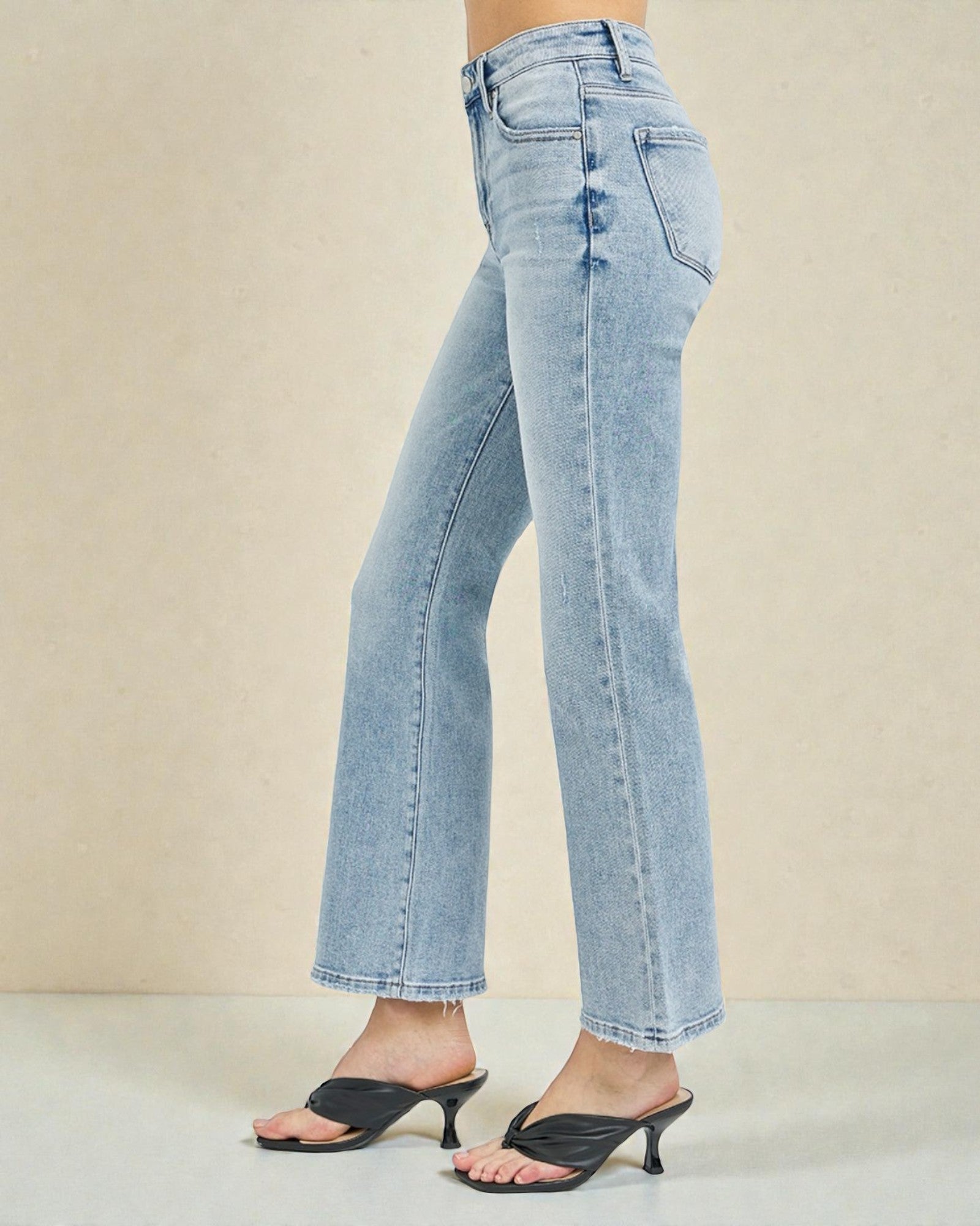 Light blue jeans worn by a person on a beige background