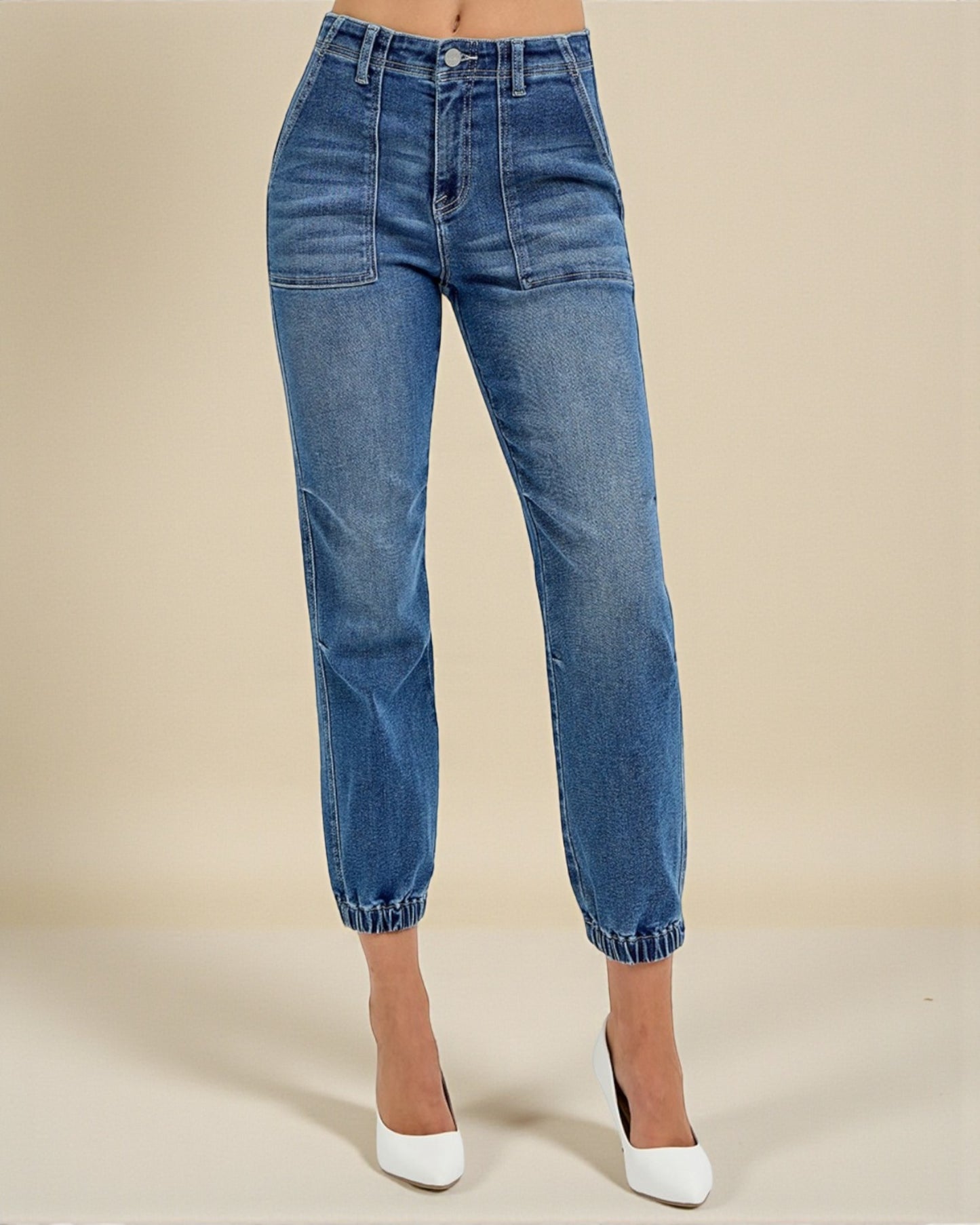 Blue jeans worn by a person on a beige background