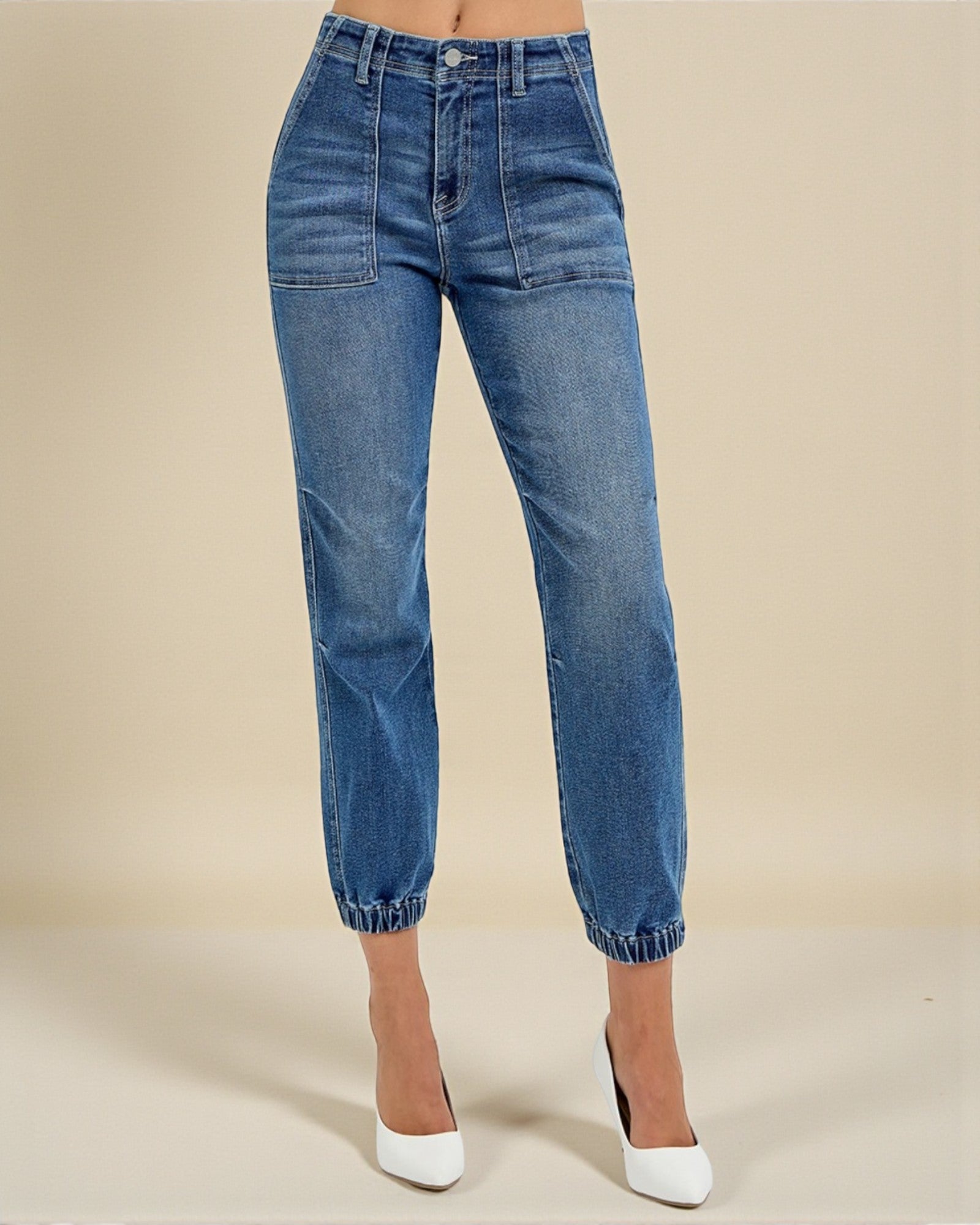 Blue jeans worn by a person on a beige background