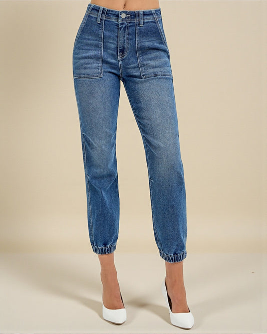 Blue jeans worn by a person on a beige background