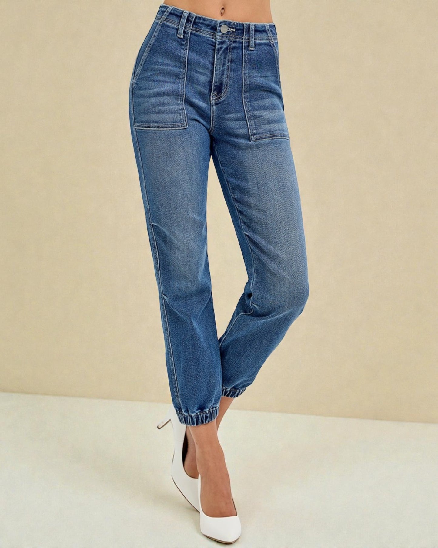 Blue jeans worn by a person on a beige background