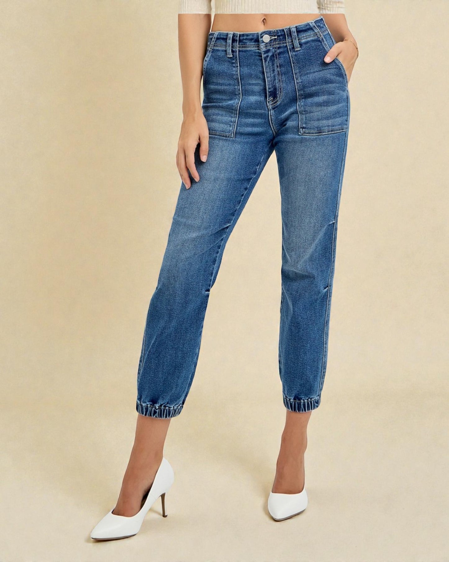 Person wearing blue jeans on a beige background