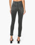 Rear view of a model wearing dark gray washed skinny jeans with rolled cuffs and black block-heel sandals against a plain white background.