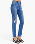 A person wearing blue skinny jeans with a distressed rip on the left thigh, paired with black heeled slide sandals, shown against a plain light gray studio background.