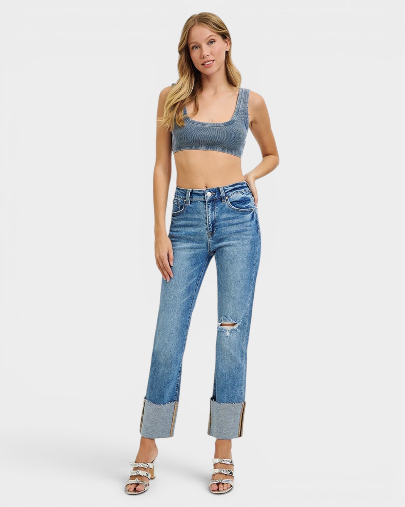 Woman wearing a denim crop top and jeans on a white background