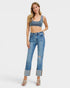 Woman wearing a denim crop top and jeans on a white background