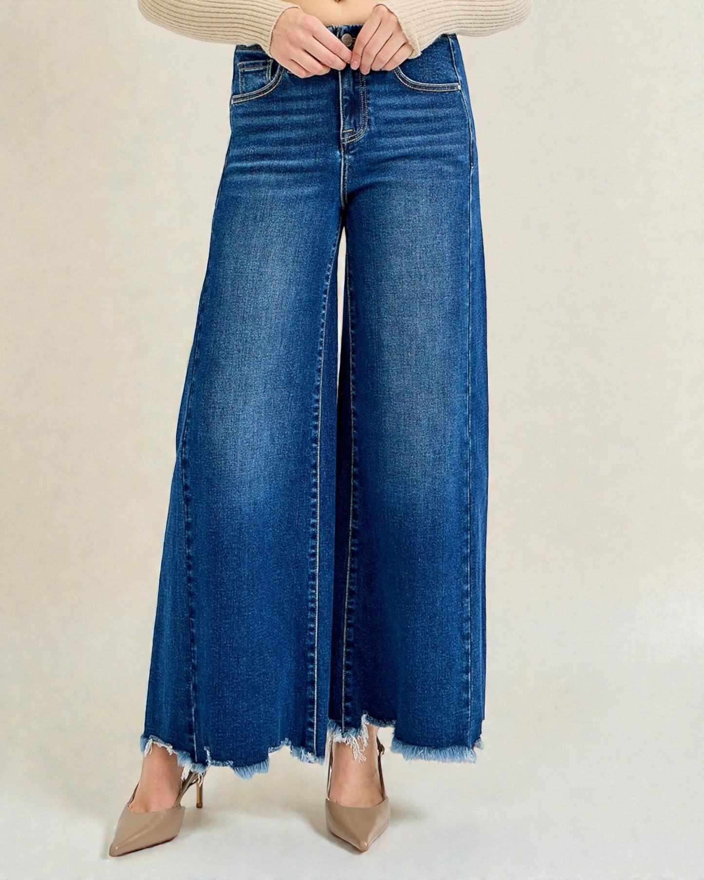 Person wearing blue wide-leg jeans on a plain background