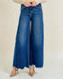 Person wearing blue wide-leg jeans on a plain background