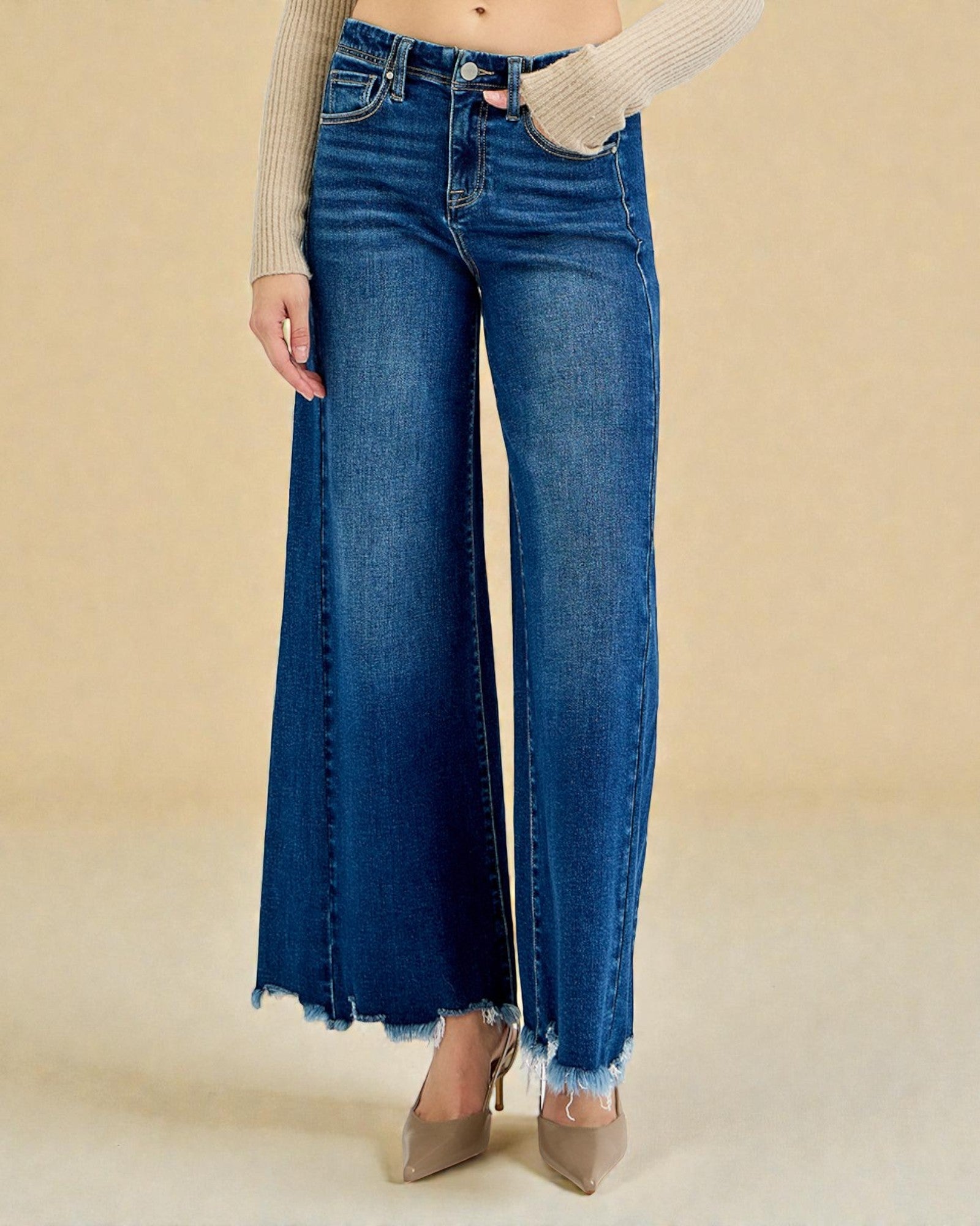 Blue jeans worn by a person on a beige background