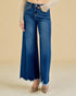 Blue jeans worn by a person on a beige background
