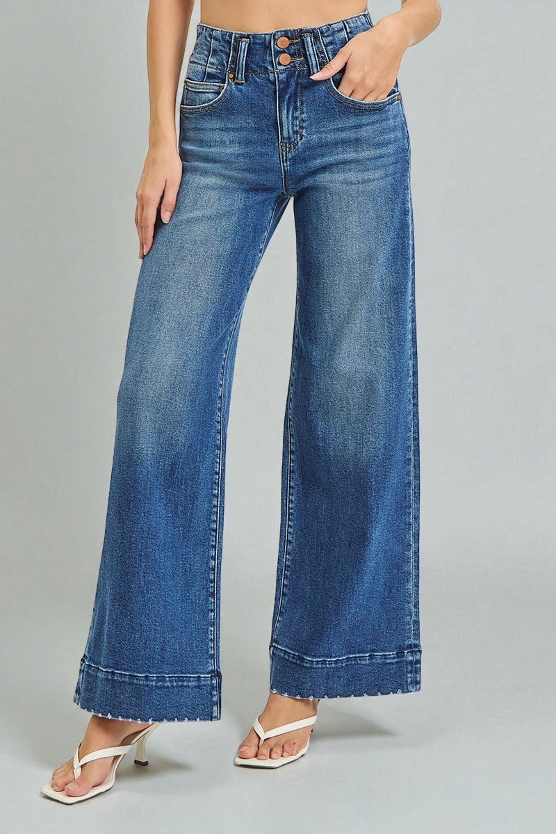 Blue wide-leg jeans worn by a person on a gray background