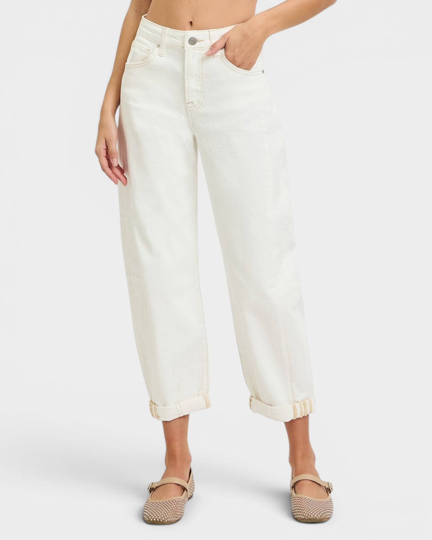 Person wearing white jeans on a plain background