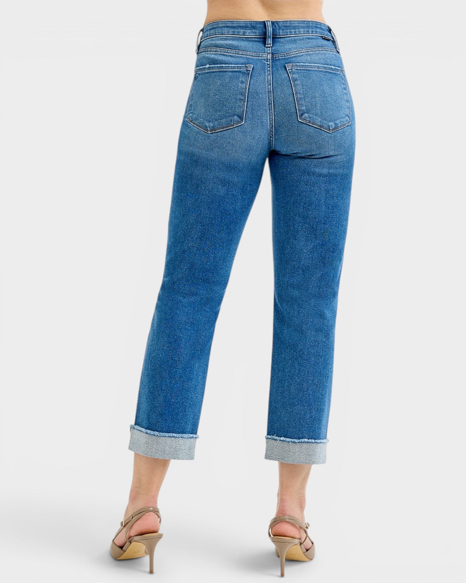 Blue jeans worn by a person on a white background