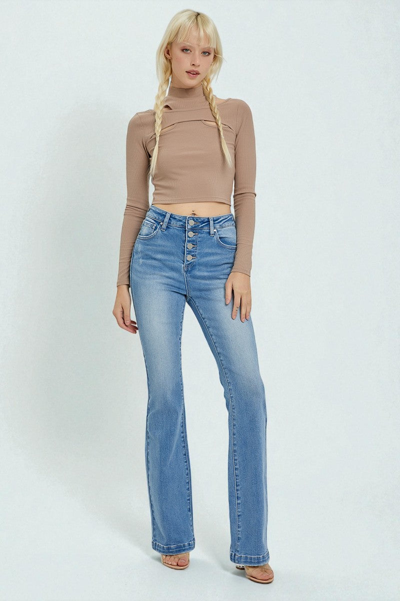 Woman wearing a beige long-sleeve top and blue jeans on a white background