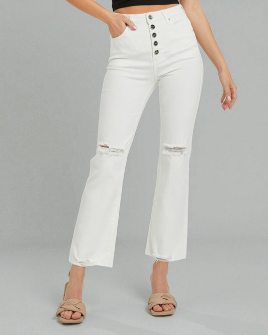 White distressed jeans worn by a person on a gray background