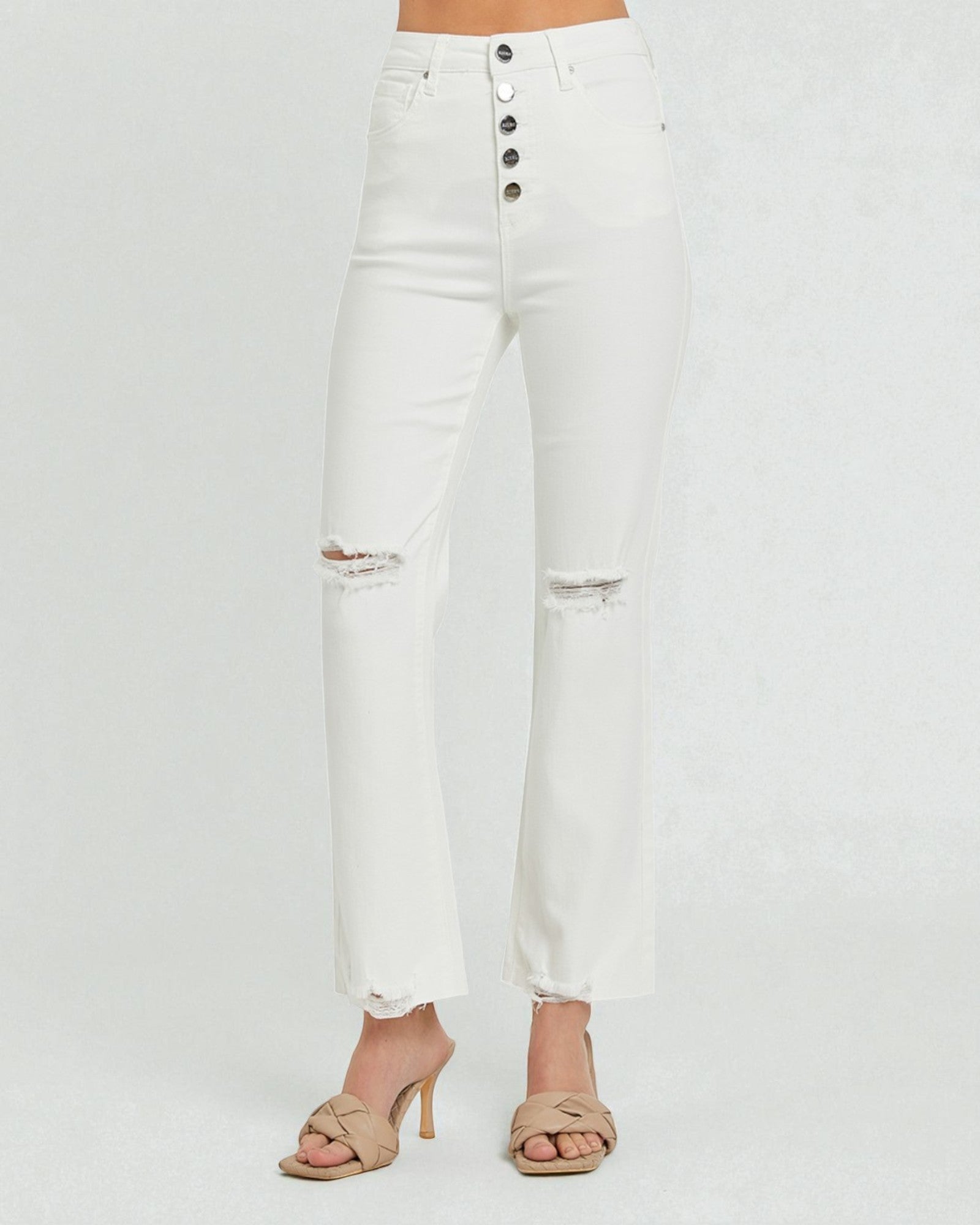 White distressed jeans worn by a person on a white background