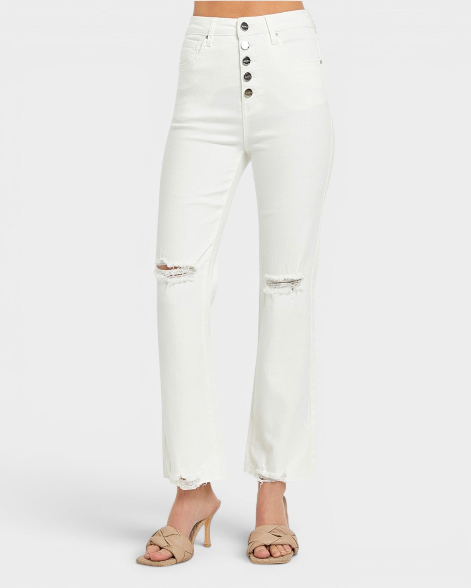 White high-waisted cropped jeans with a five-button fly and distressed rips at the knees, shown on a model wearing beige heeled sandals against a light gray background.