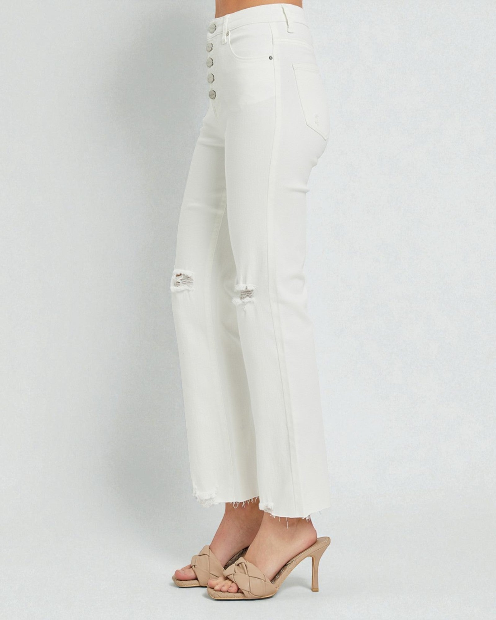 White distressed jeans on a plain background