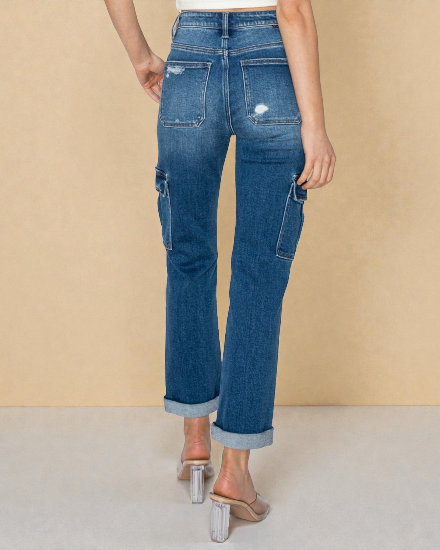 Person wearing blue jeans on a beige background